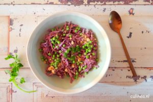 Geraspte paarse wortelsalade in een bord