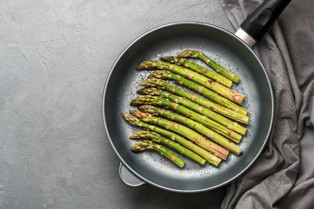 groene asperges die bakken in een pan