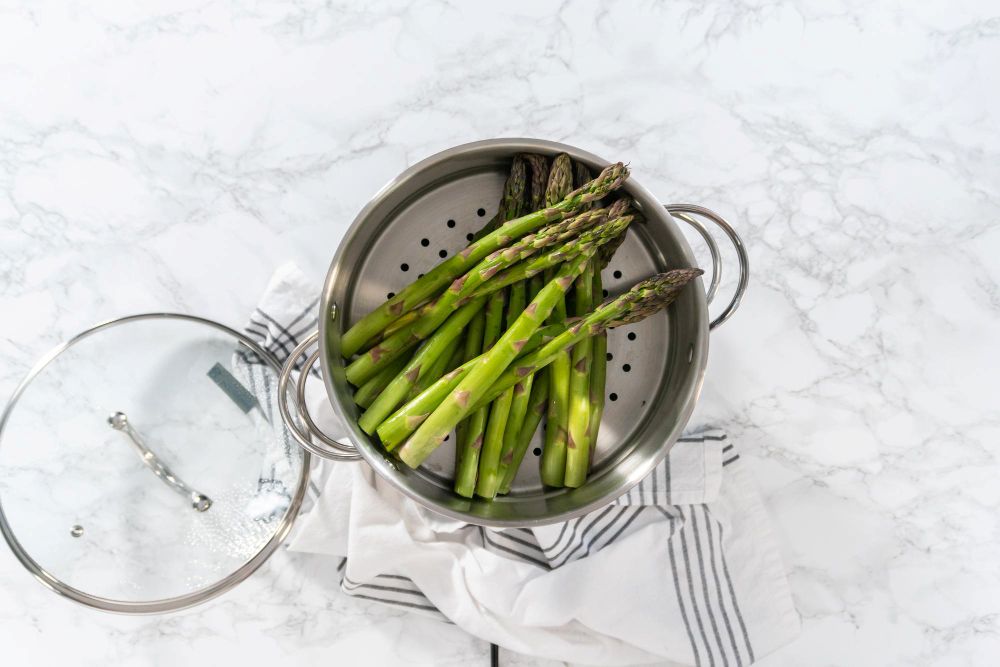 gekookte groene asperges boven een pan