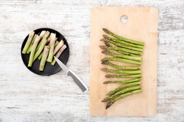 groene asperges gesneden op een snijplank