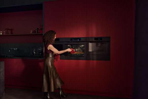 een vrouw die iets uit de oven haalt